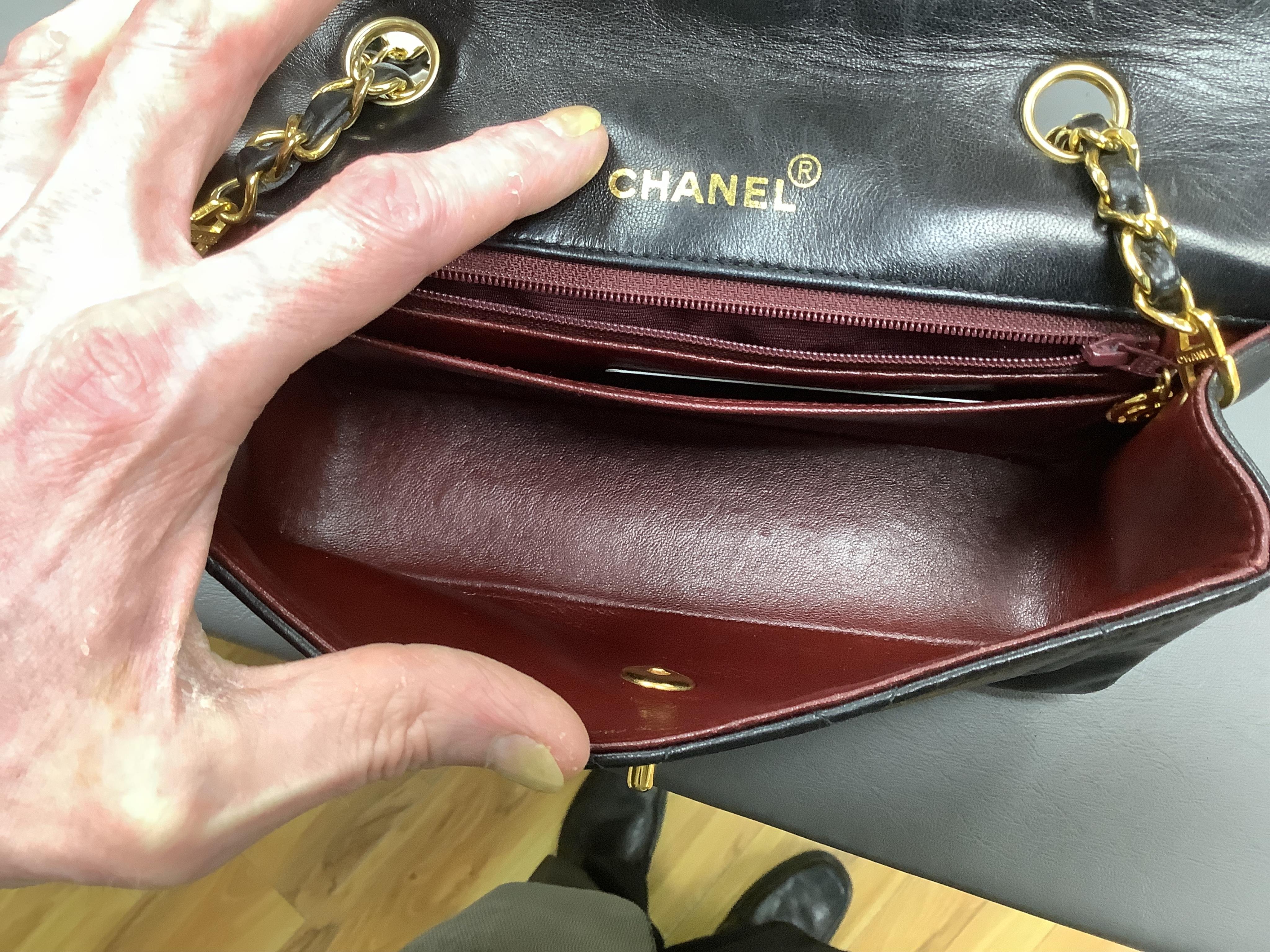 A late 1980’s Chanel black leather Diana shoulder bag with original dust cover and bag, Chanel authenticity card numbered 1944645, interior date code rubbed, 23cm wide, Provenance: Purchased by the vendor, 26 Old Bond St